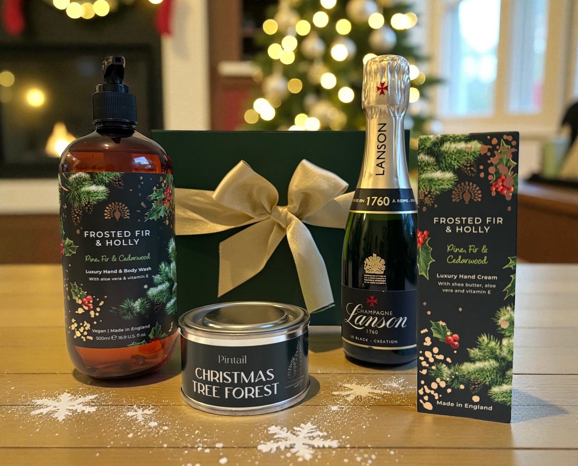 Festive gift set with Lanson Champagne, Frosted Fir & Holly wash and hand cream, and a Christmas Tree Forest candle in a green box with gold bow.