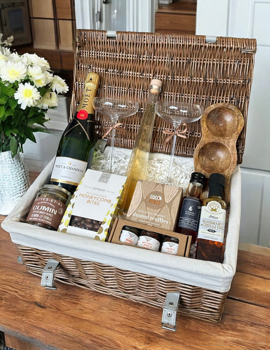 Luxury celebration hamper with Moët & Chandon, artisanal liqueur, chocolate truffles, chutneys, champagne glasses, and dipping platter.
