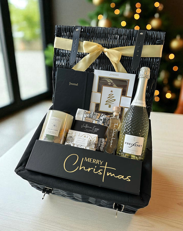 Christmas Fizz and Treats Hamper featuring Freixenet Prosecco in Merry Christmas box, journal, French Connection candle, London Soap, tea towel, Chocolate slab, and Oxton Liqueur.
