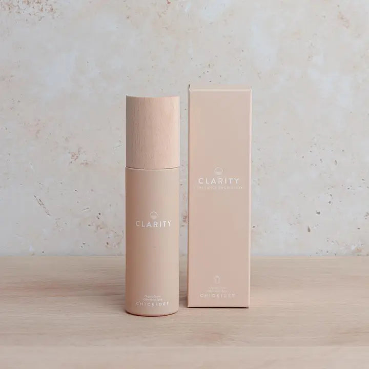 Clarity Room Spray bottle and packaging on a wooden surface.
