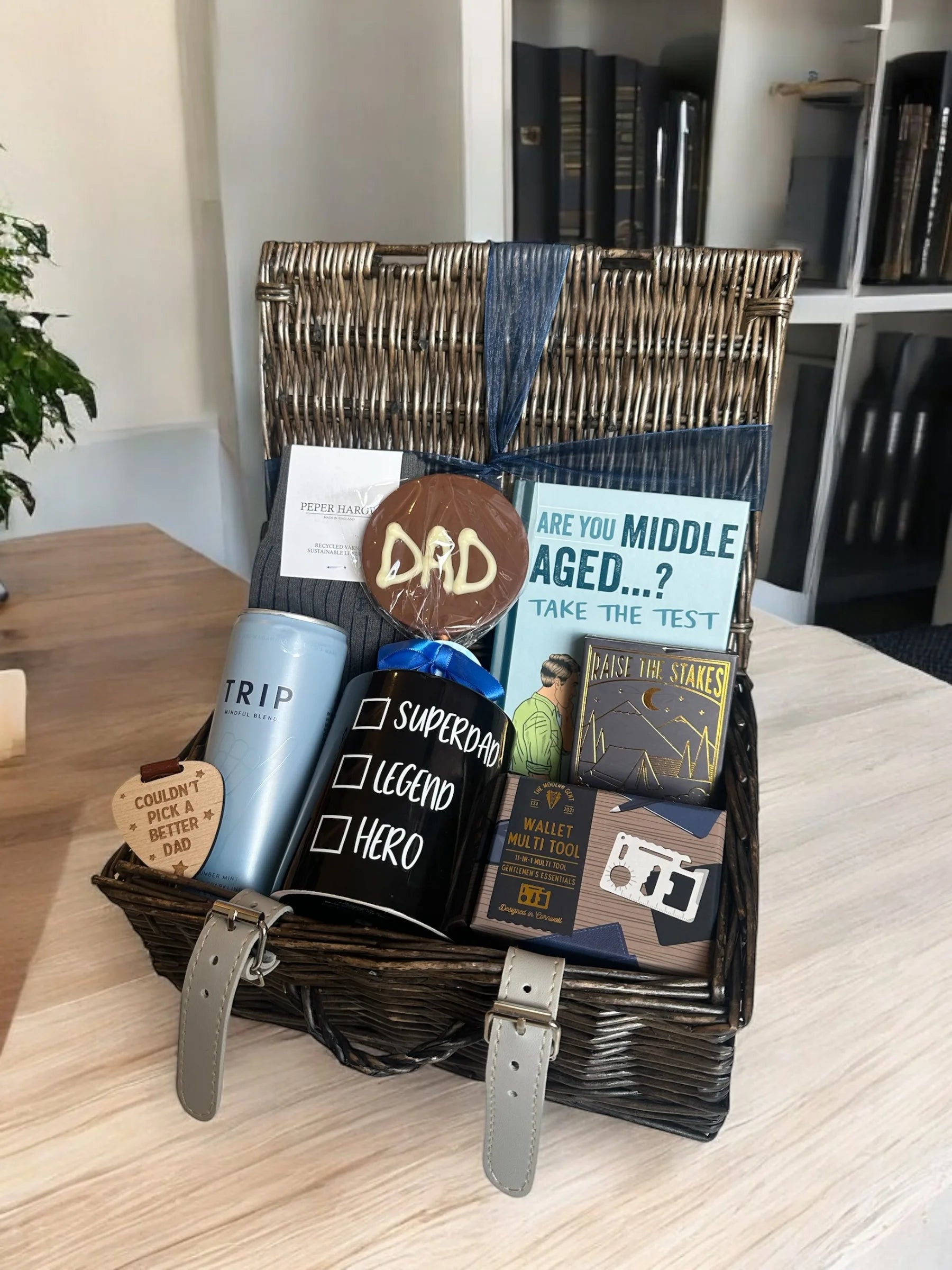 Dad Appreciation Box filled with gifts, including mugs, books, and a card, on a wooden table.