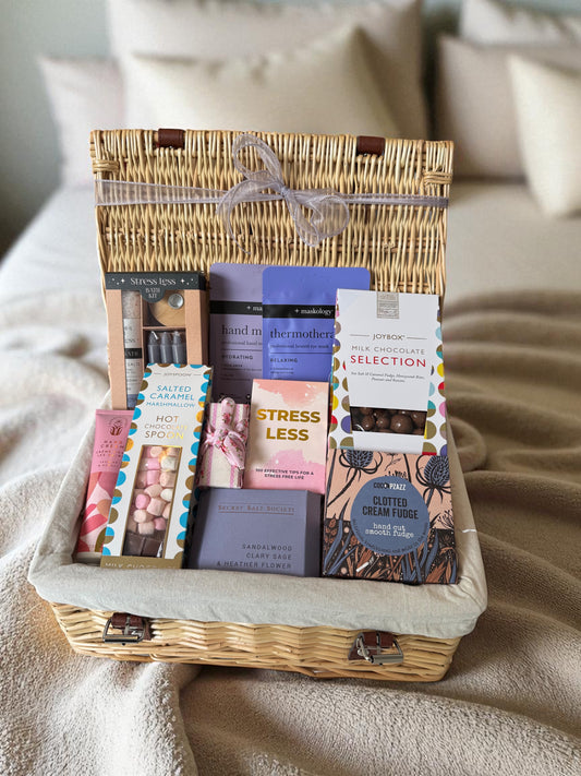 De-Stress & Recharge Hamper featuring Stress Less bath kit, face mask, jasmine & neroli hand cream, hydrating hand masks, chocolates, hot chocolate spoon, and clotted cream fudge.