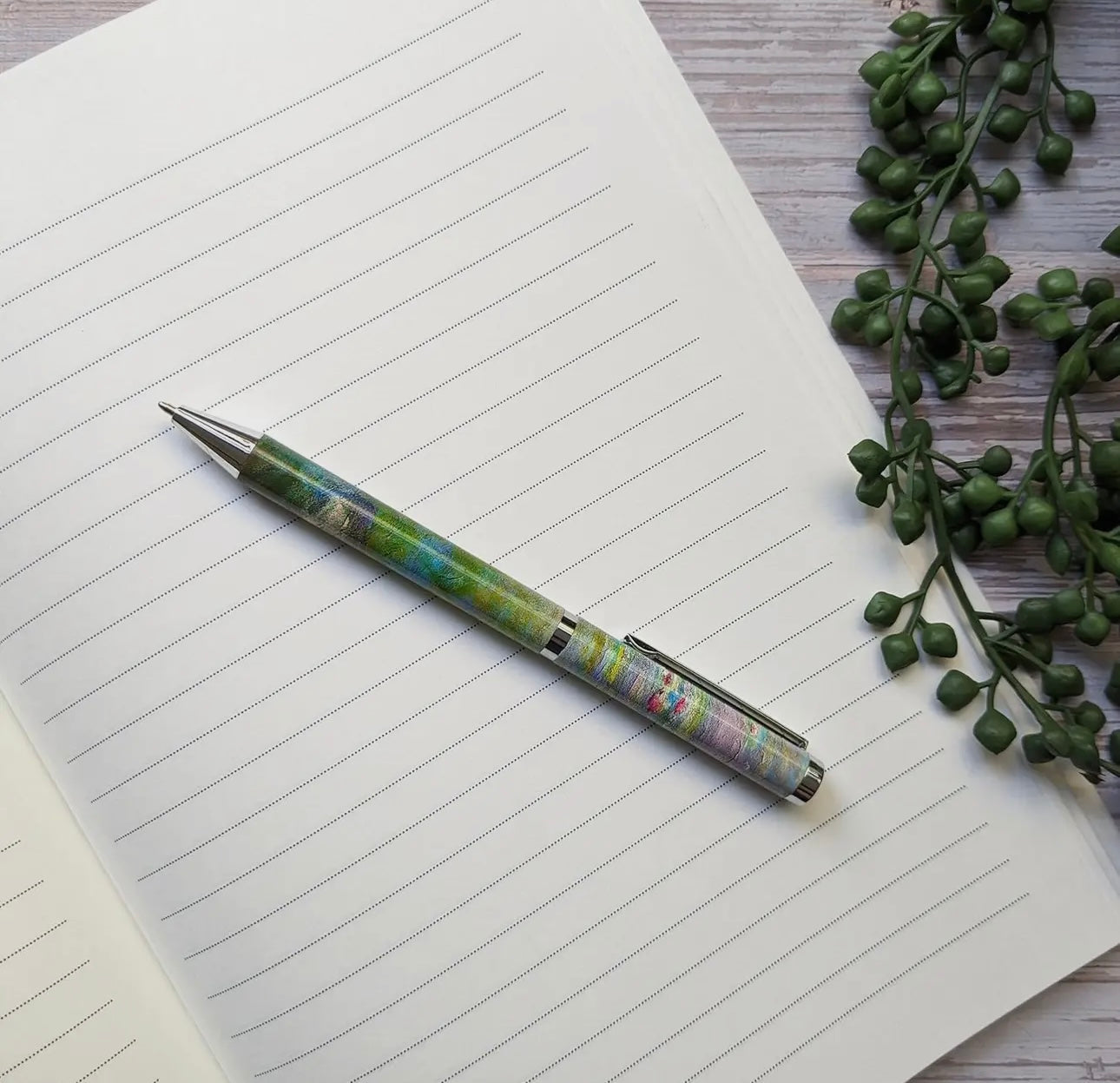 Waterlilies Ballpoint Pen with Monet design on lined notebook.