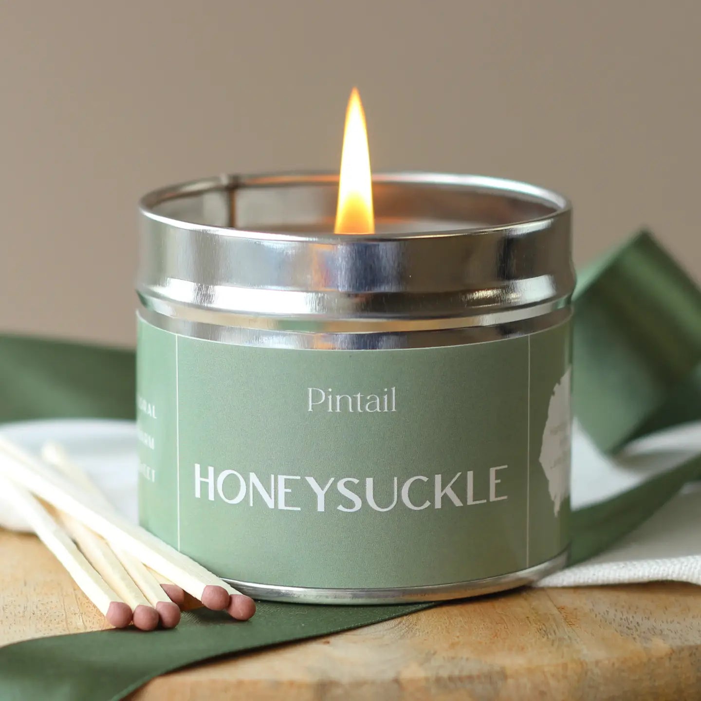 Honeysuckle Classic Tin Candle with floral and musk scent on display.