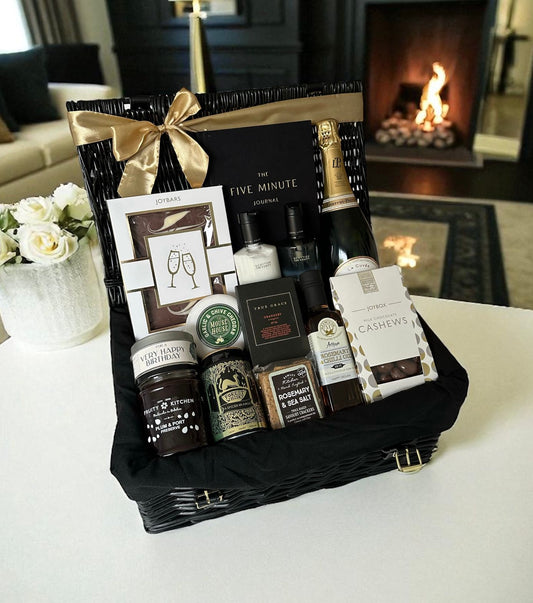 Gentlemen’s Birthday Hamper with champagne, cheese, chocolate & luxury keepsakes in a black wicker basket.