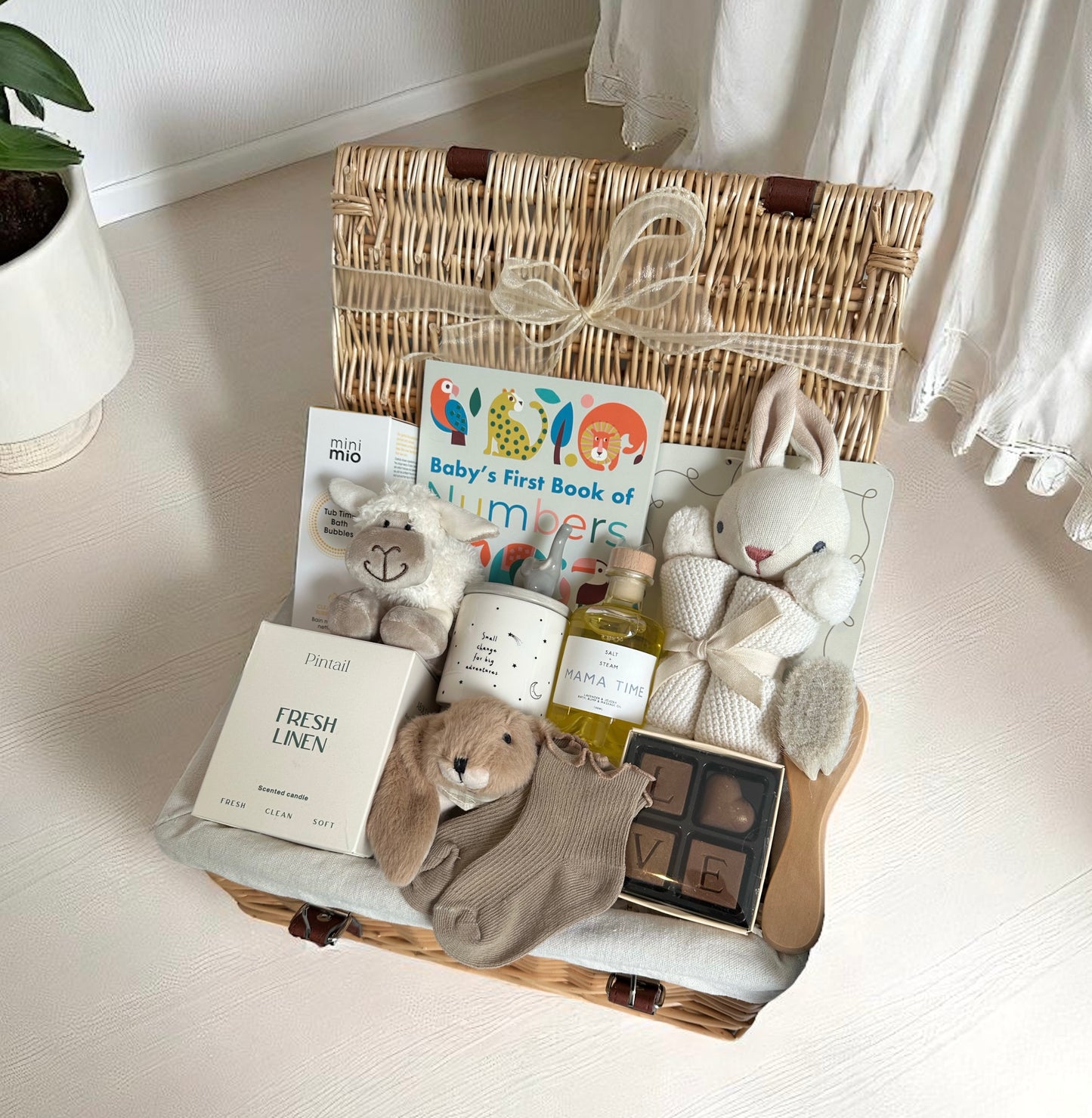 Baby gift hamper with soft toys, candle, chocolates and bath oils.