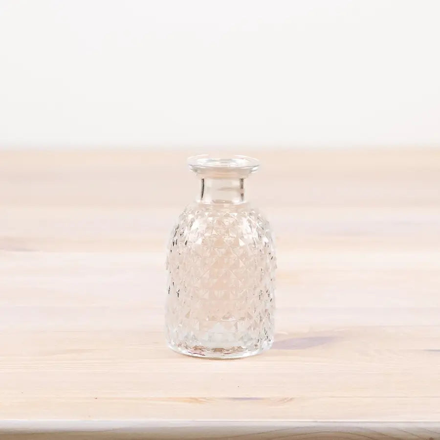 Patterned glass flower vase, 9.2cm tall, clear design.
