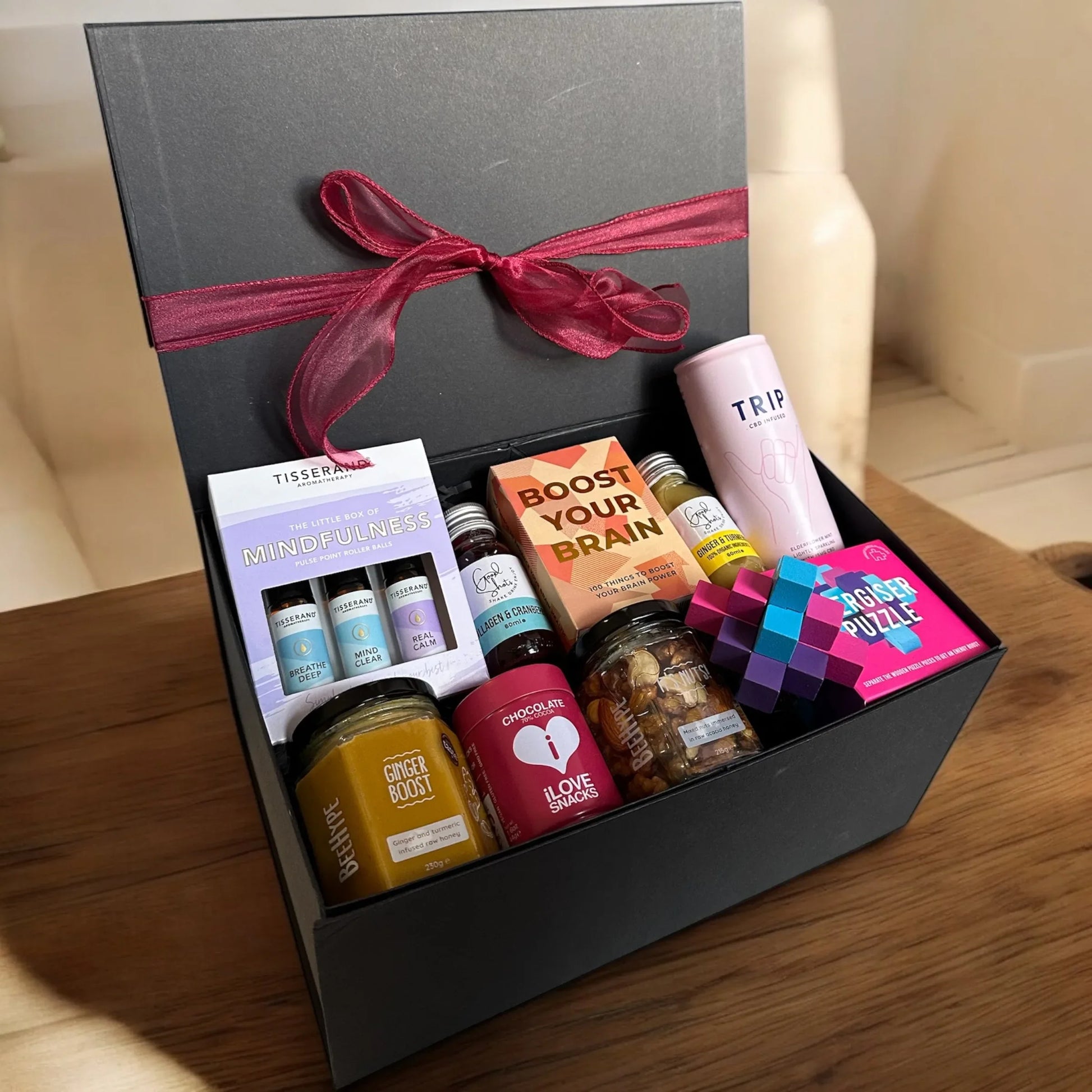 Brain Boosting Gift Box with Tisserand oils, energiser puzzle, ginger chocolate, boost cards, cranberry shots, TRIP drink, honey nuts.