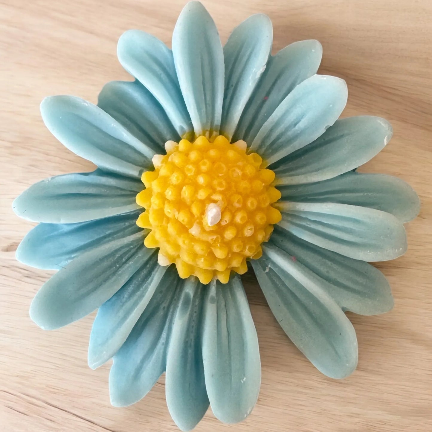 Blue Daisy Mini Candle shaped like a blue and yellow daisy flower.