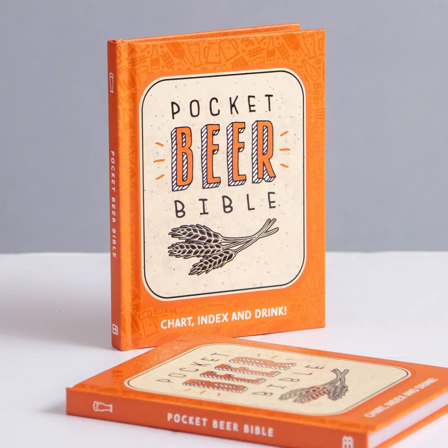 Pocket Beer Bible book with orange cover featuring text and hop illustration.