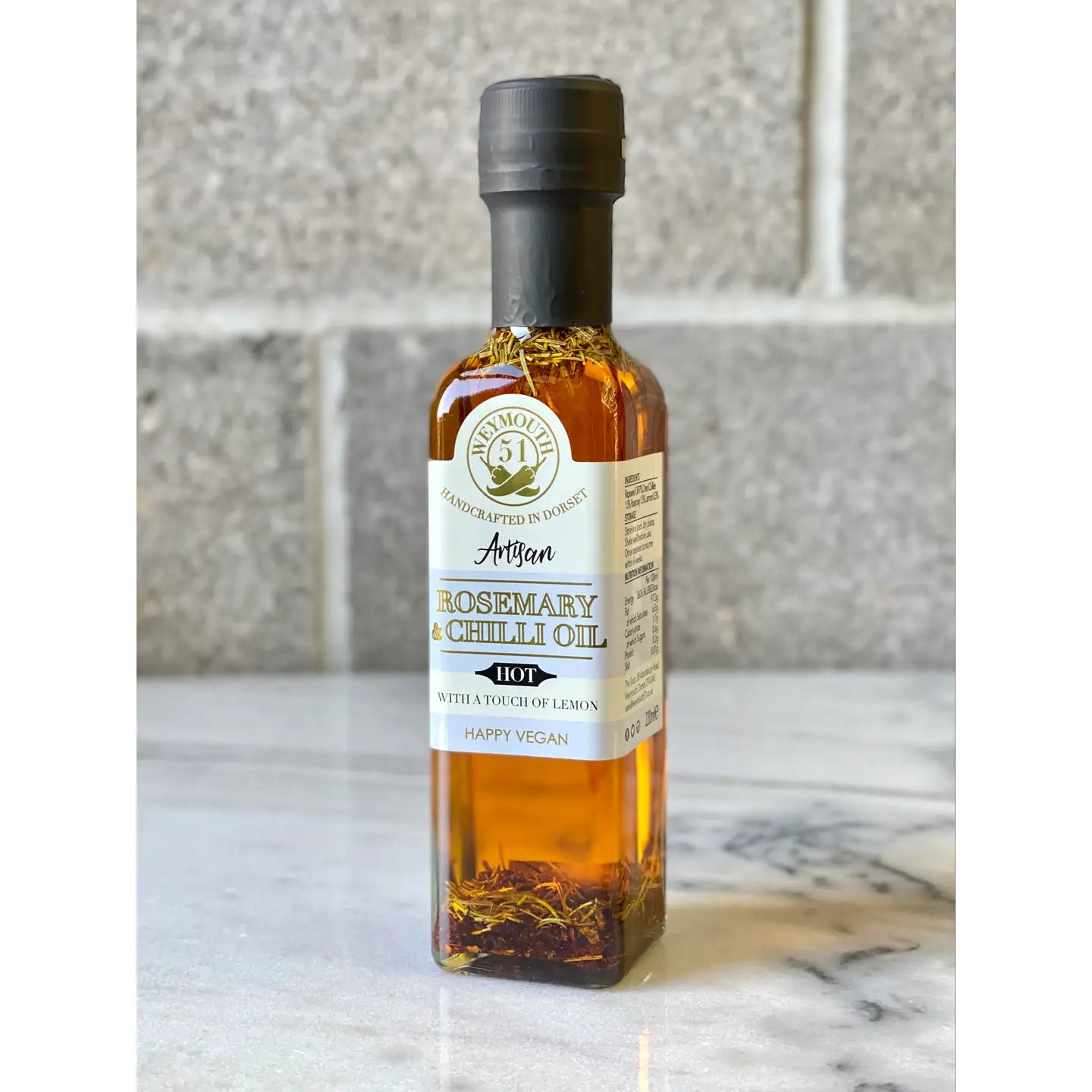 Rosemary Chilli & Lemon Rapeseed Oil 220ml bottle on marble surface.