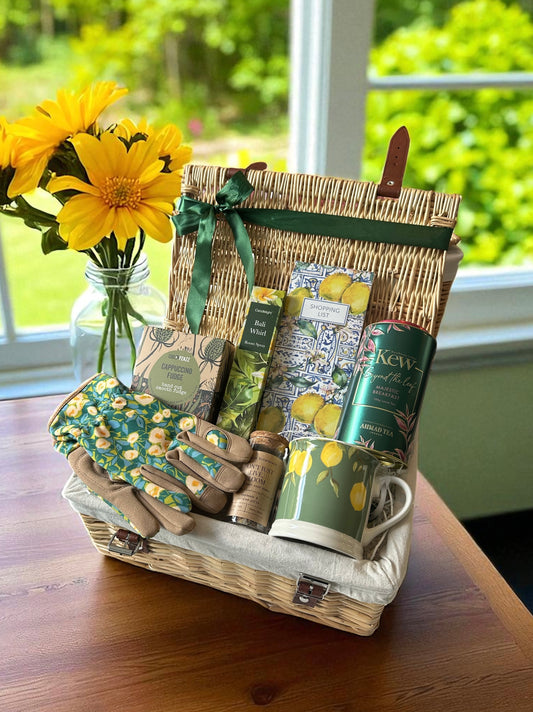 Sweet Retirement Gift Basket featuring lemon mug, Kew Gardens loose-leaf tea, notebook, Bali Whirl room spray, cappuccino fudge, gardening gloves, and seed balls.