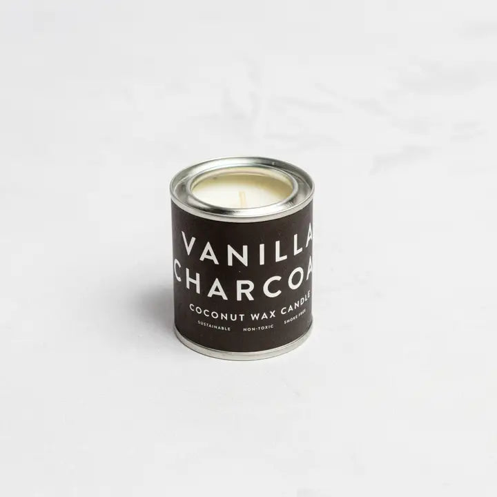 Vanilla Charcoal Conscious Candle in dark tin container.