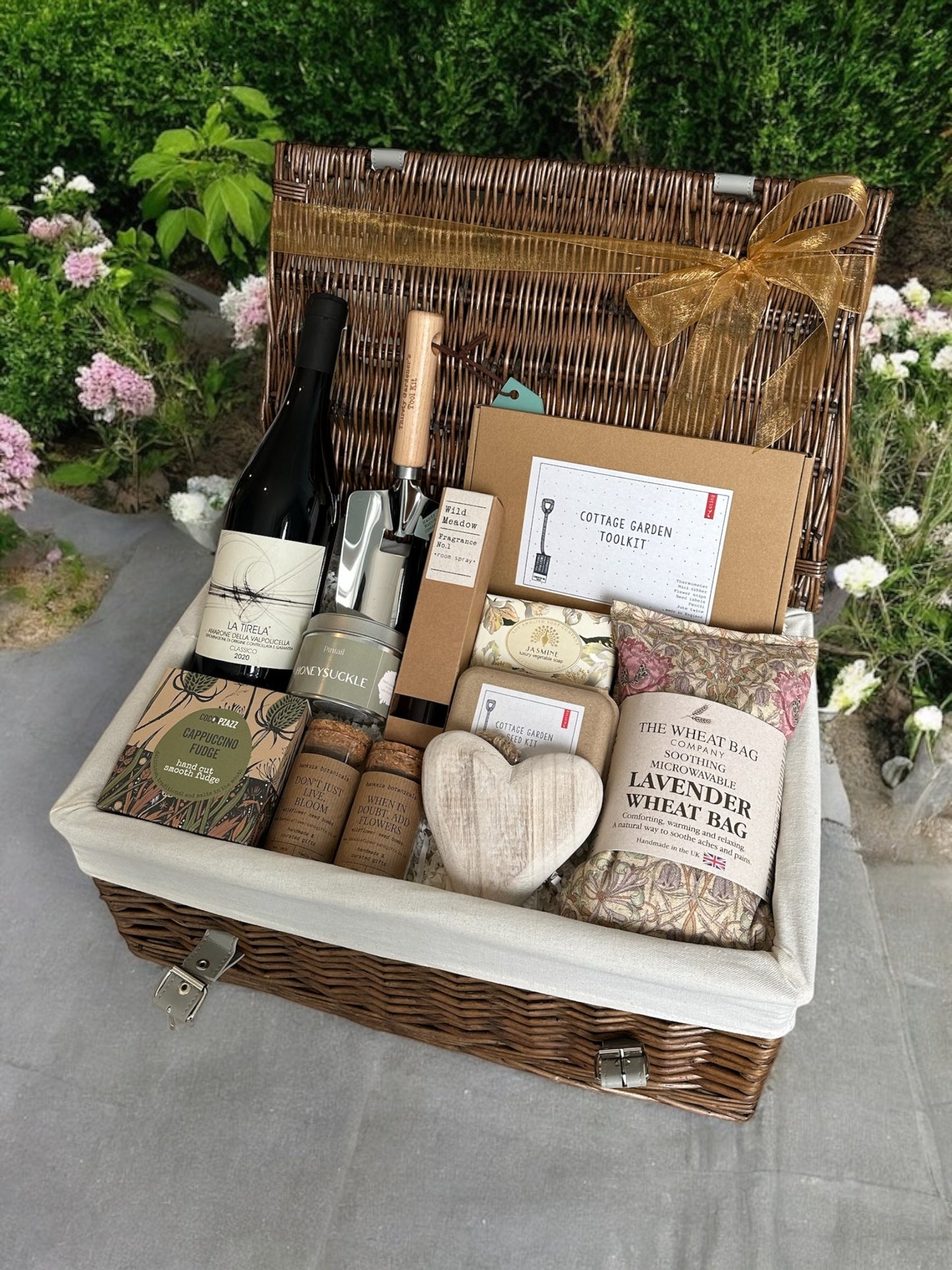 Amarone in the Garden Hamper with cottage garden seed set, tools, honeysuckle candle, wild meadow spray, jasmine soap, lavender wheat bag, hanging heart, Amarone wine, and butter fudge.
