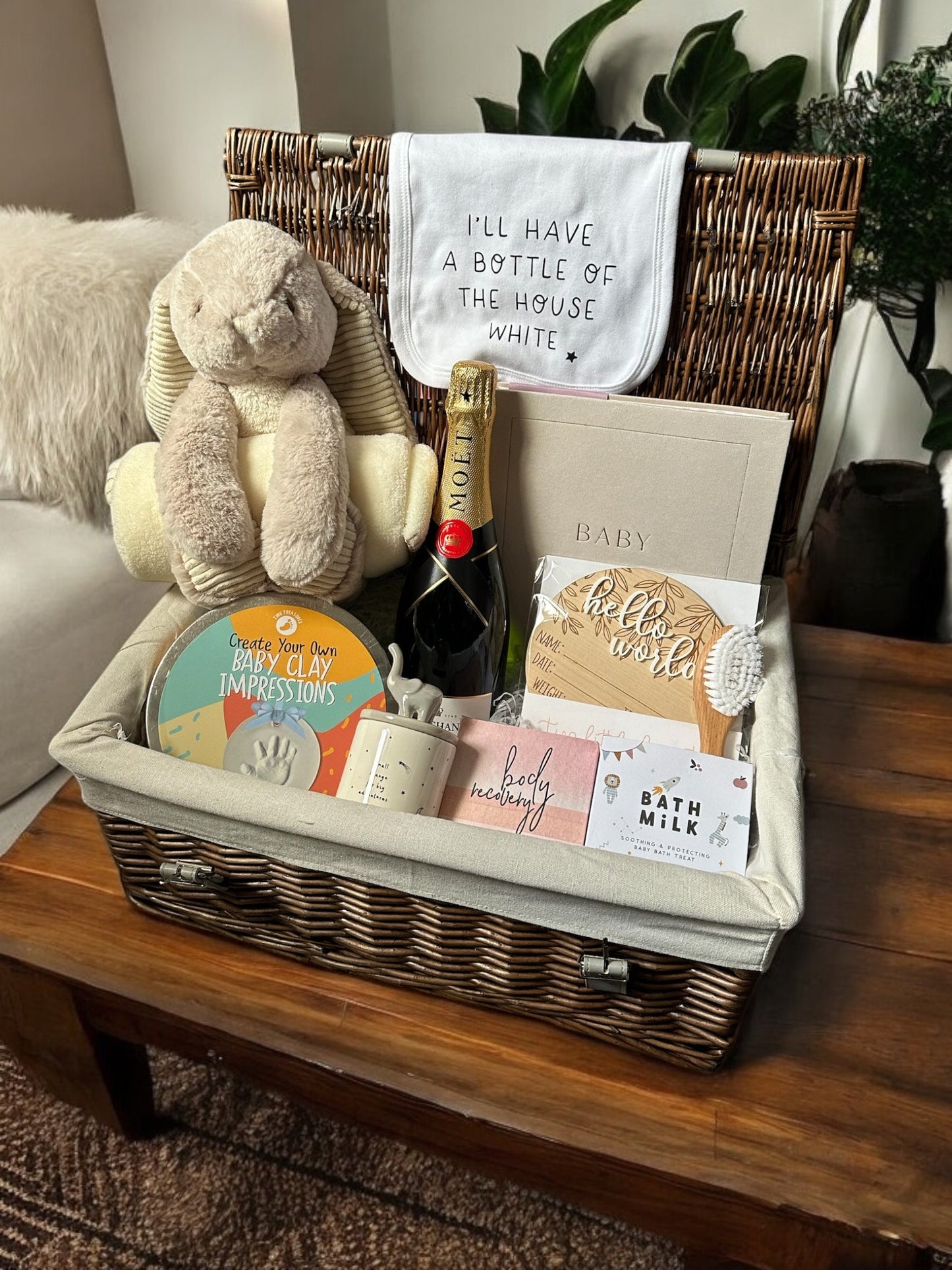 Memory & Relaxation Hamper with baby essentials, champagne, bunny teddy, and photo prop.