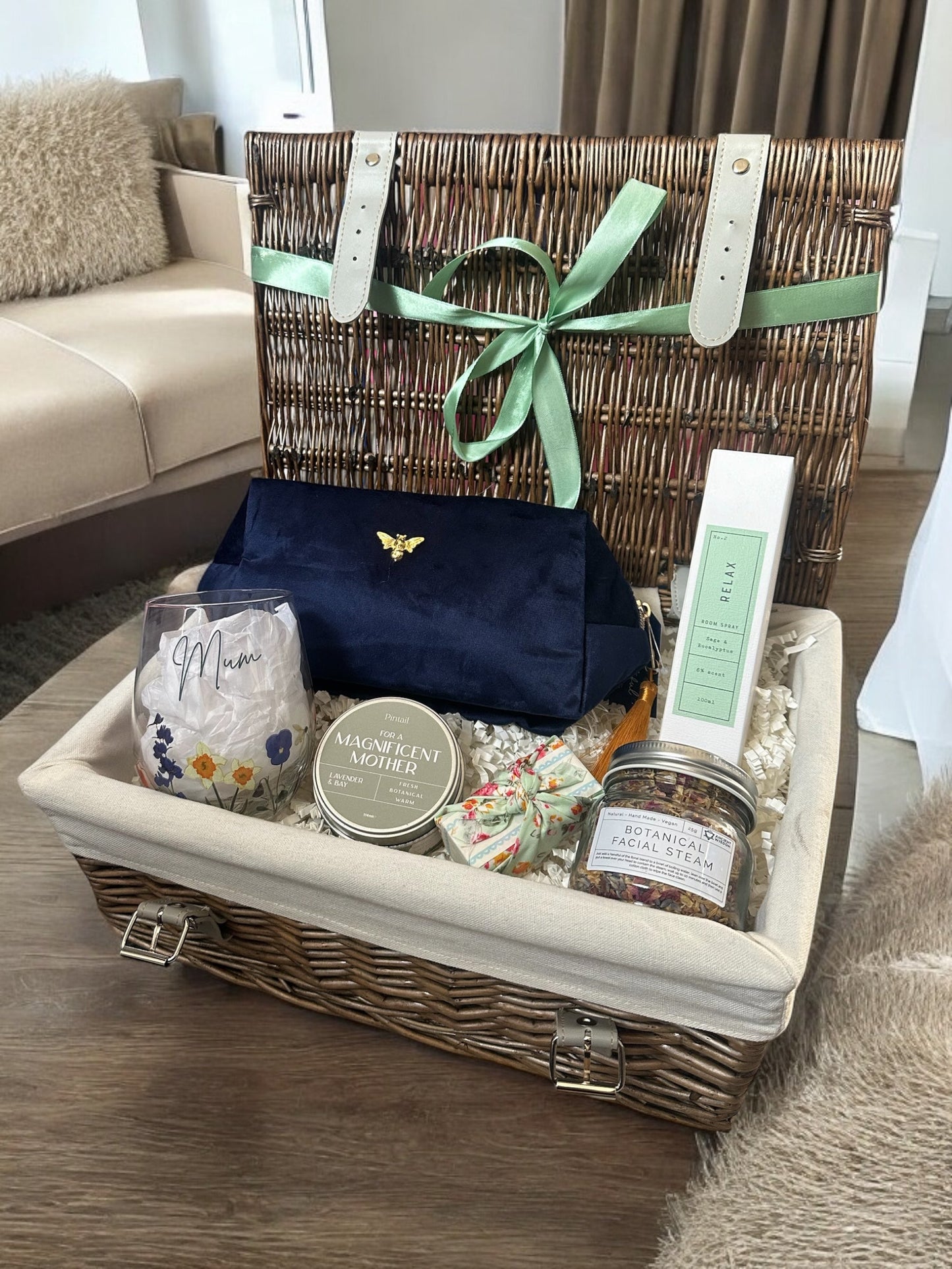 Mum's Tranquil Escape Hamper with room spray, makeup bag, facial steam, soap, a candle, and a glass.