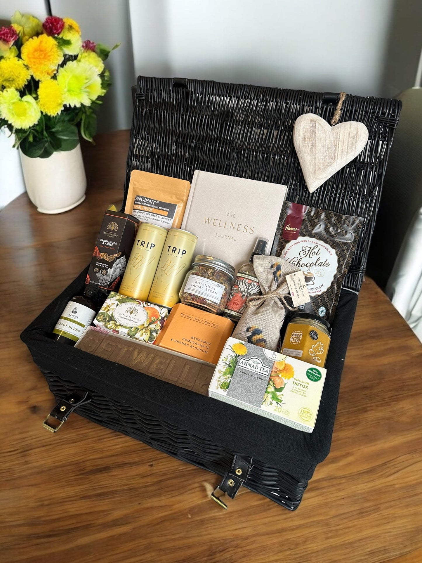 On The Mend gift box with sweet treats, calming drinks, ginger honey, energy blend, wellness journal, detox bath salts, and botanical facial steam.