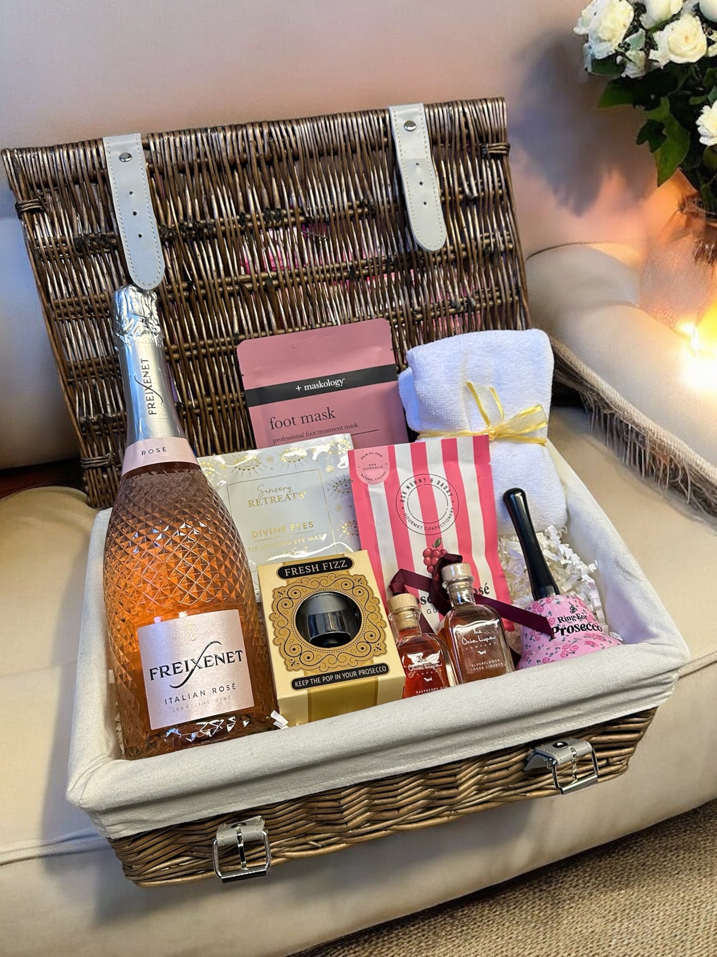 Prosecco Lover's Hamper with Freixenet Prosecco, gummies, liqueurs, and relaxation items in a wicker basket.