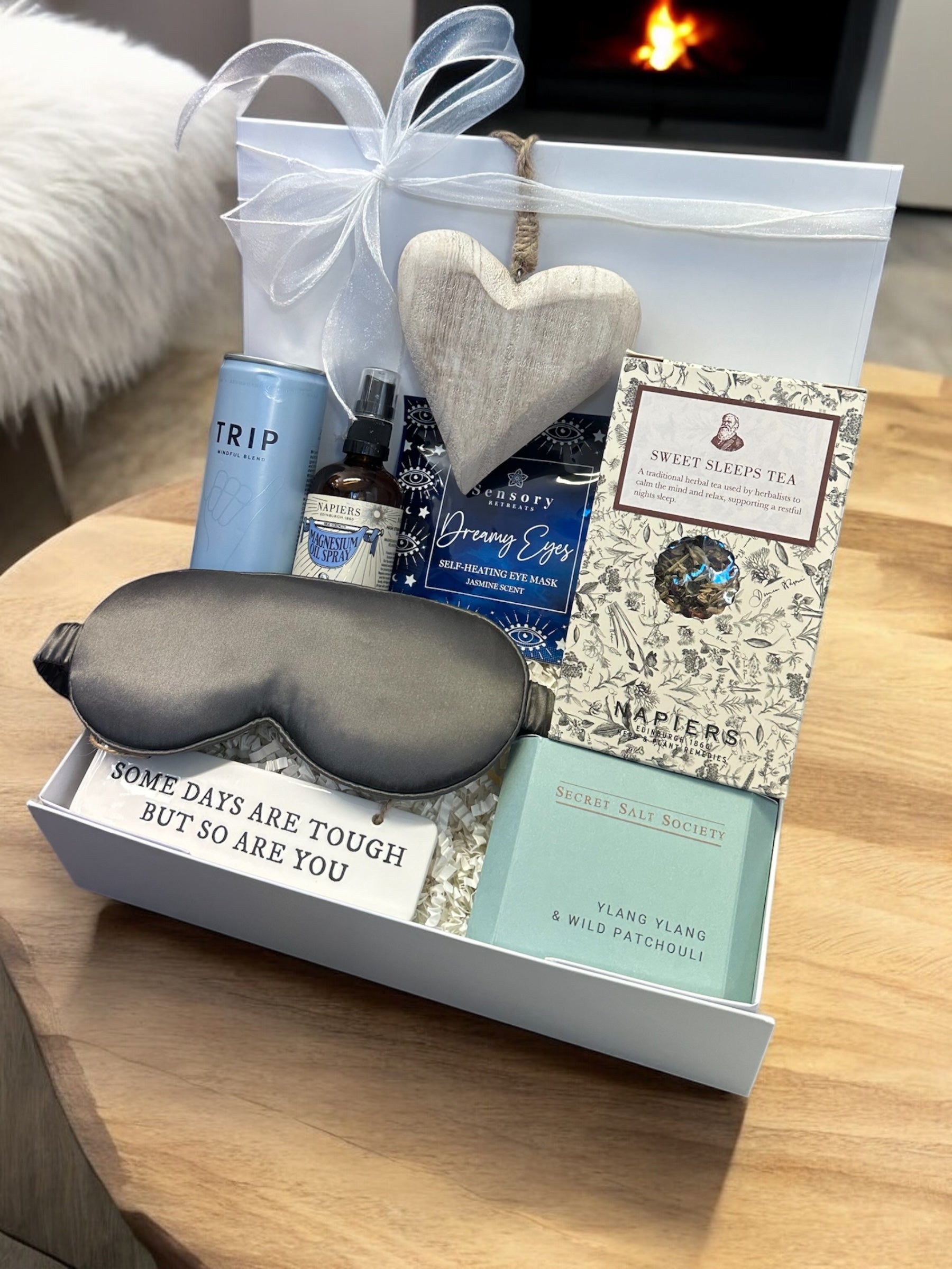 Rest and Recover Hamper with silk eye mask, magnesium oil spray, ylang ylang bath infusion, CBD drink, Sweet Sleeps tea, and inspirational signs.