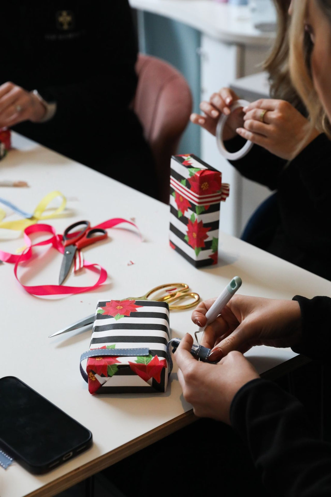 Top Hampers team members professionally wrapping corporate gifts during a training session focused on presentation and detail