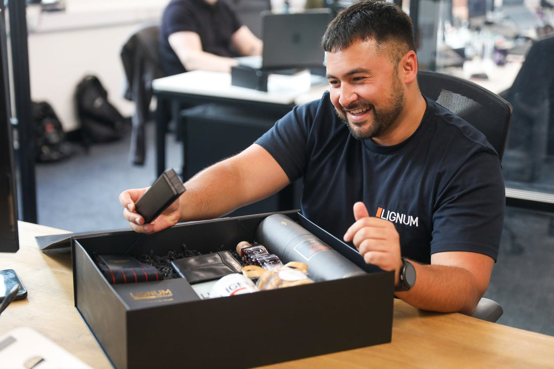 Smiling recipient opening a thoughtfully presented corporate gift hamper