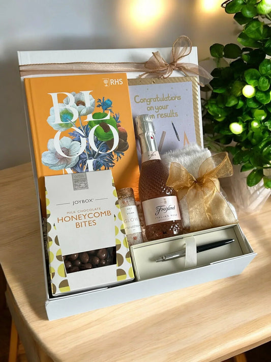 Congratulations on your exam results gift box with luxury chocolates, a celebratory drink, a note book and Parker pen in a ribbon-tied gift box. 
