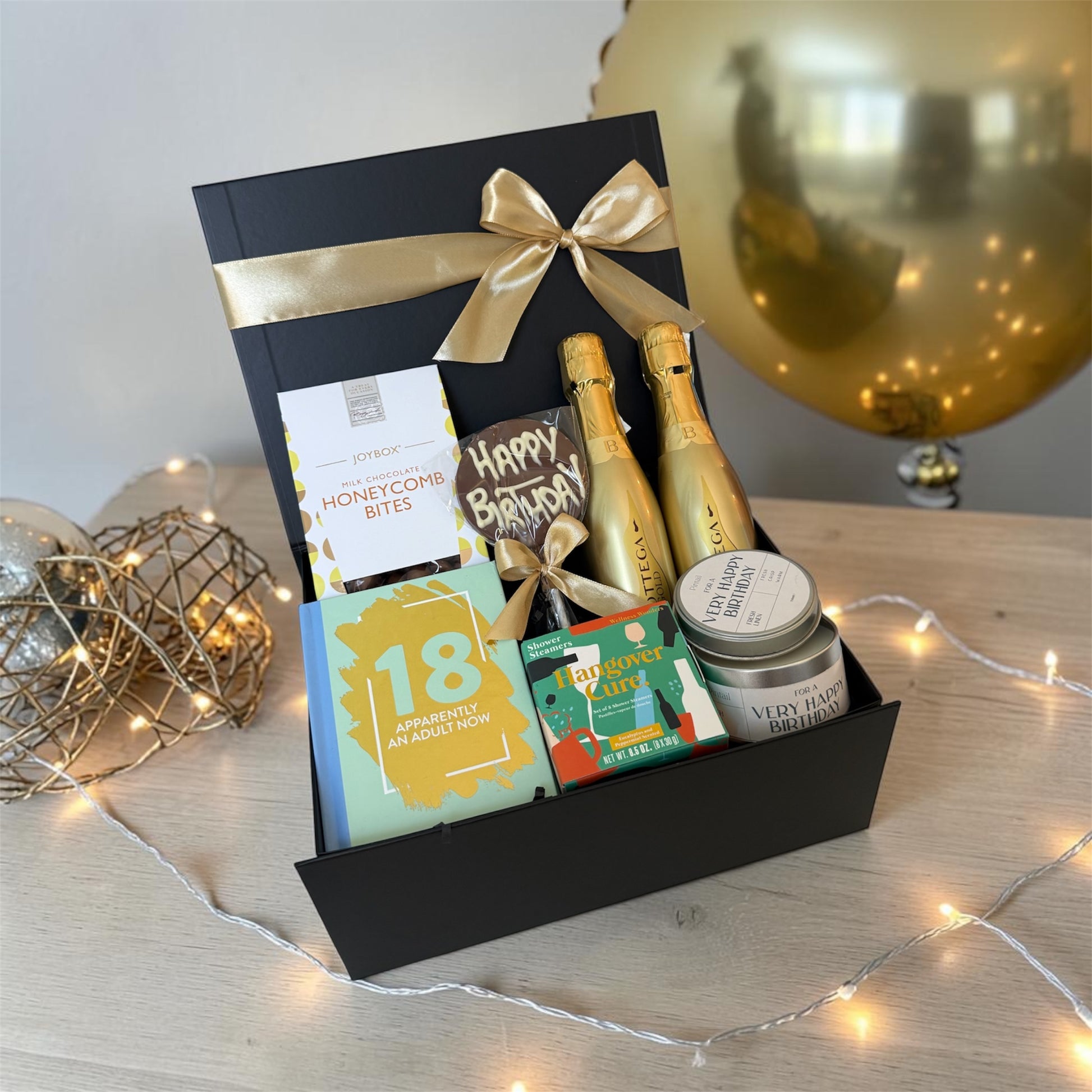 18th birthday gift box with chocolates, candle, humorous book, shower steamers and choice of prosecco or beer.