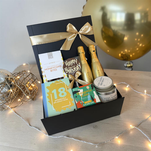 18th birthday gift box with chocolates, candle, humorous book, shower steamers and choice of prosecco or beer.