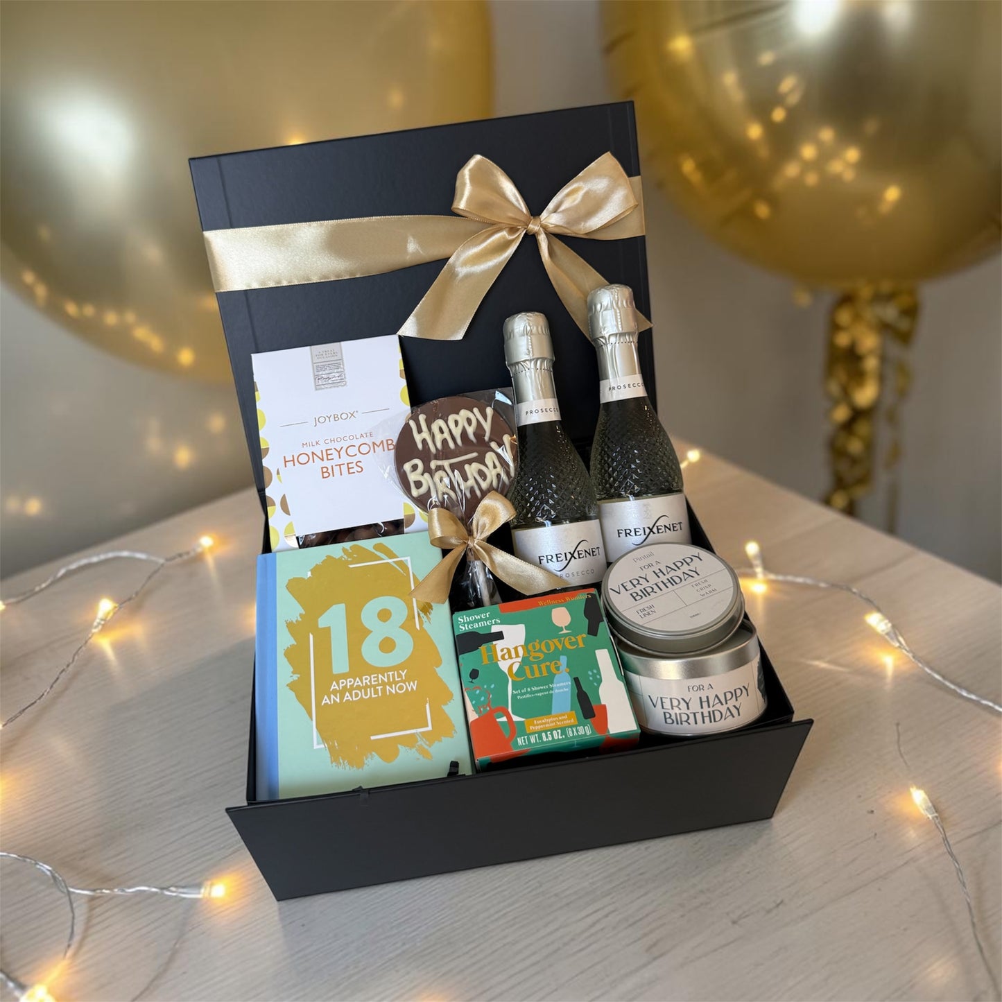 18th birthday gift box with chocolates, candle, humorous book, shower steamers and choice of prosecco or beer.