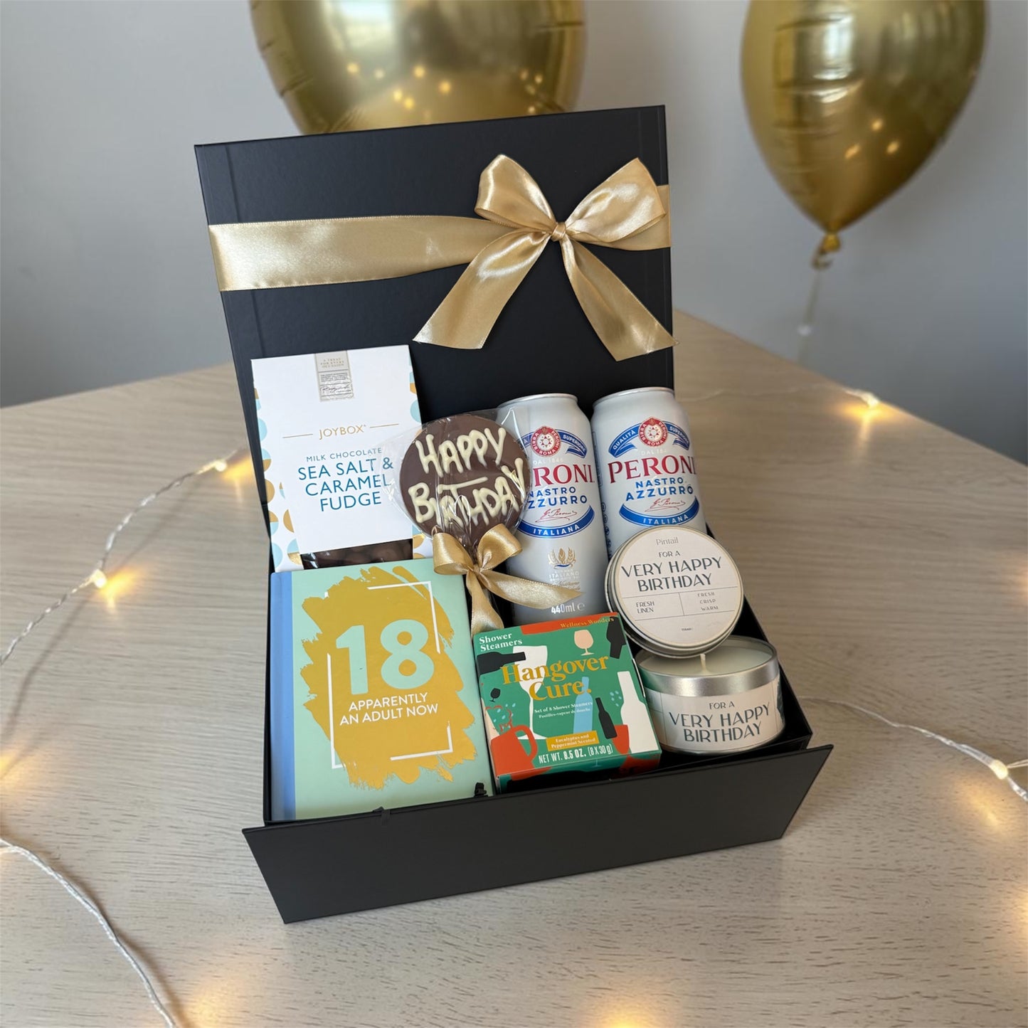 18th birthday gift box with chocolates, candle, humorous book, shower steamers and choice of prosecco or beer.