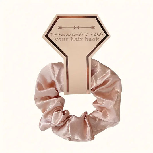 Silk scrunchie with packaging labeled "To Have And To Hold Your Hair Back".