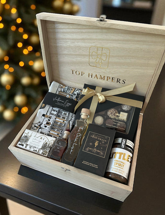 A Very British Christmas Gift Set featuring London Soap with tea towel, Oxton Elderflower liqueur & bauble, True Grace Manor room spray, Christmas coffee, and Hamiltons chocolates.
