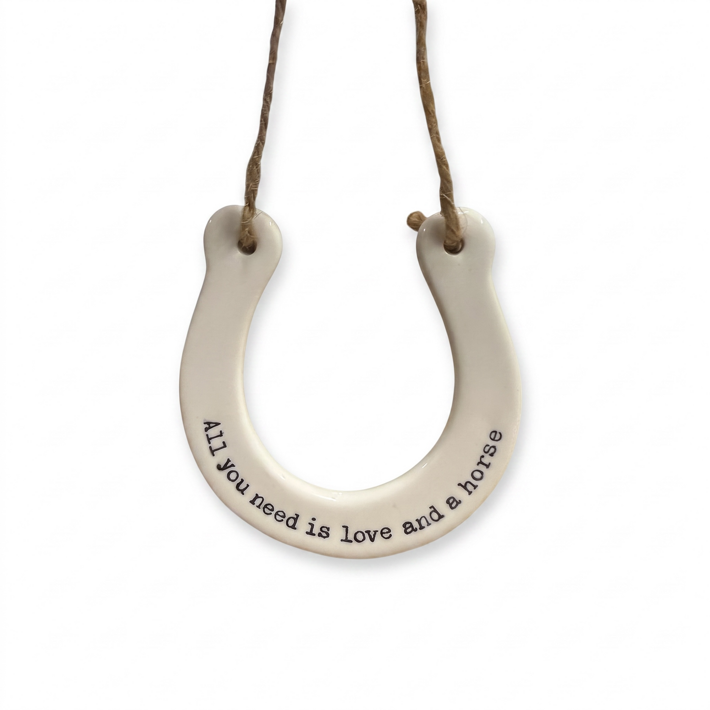 White ceramic horseshoe hanging decoration with the quote "All you need is love and a horse" and rustic twine.
