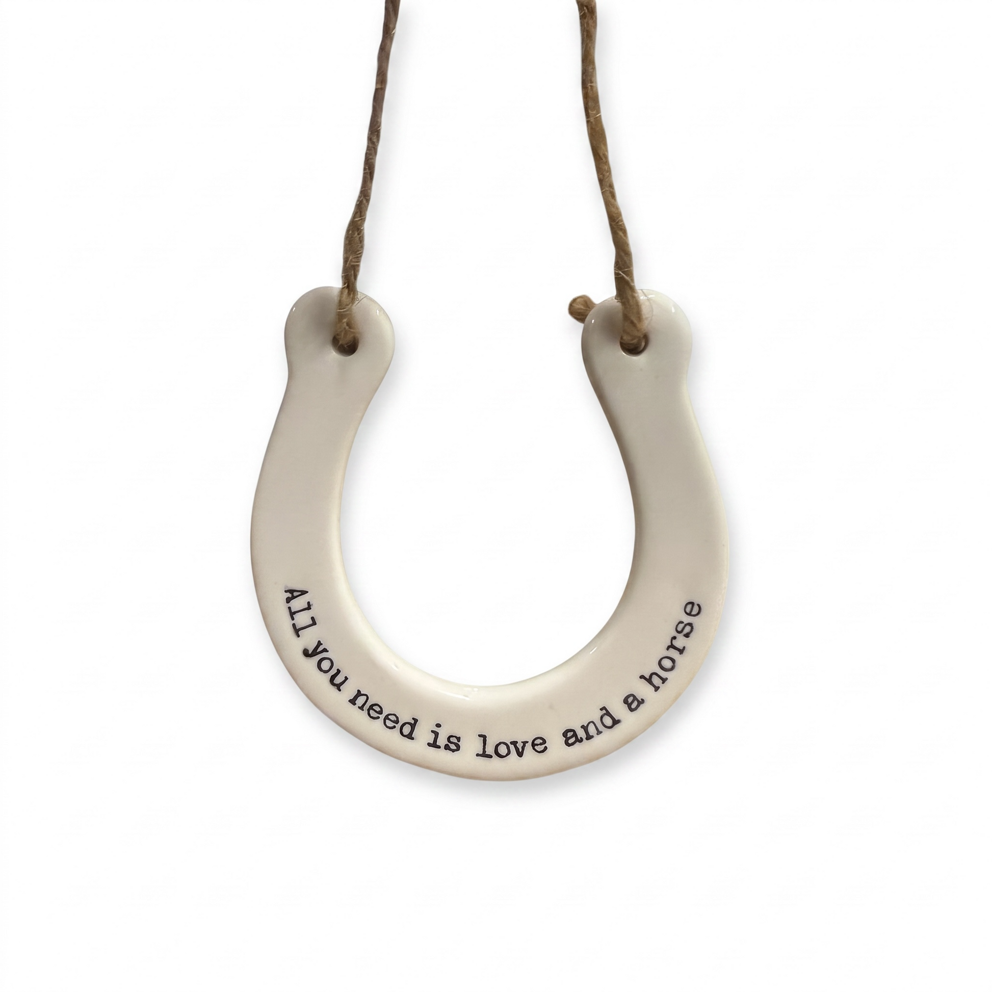 White ceramic horseshoe hanging decoration with the quote "All you need is love and a horse" and rustic twine.