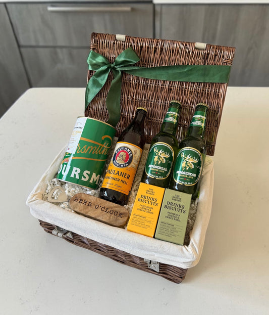 Gift basket with beer bottles and snacks on a white surface