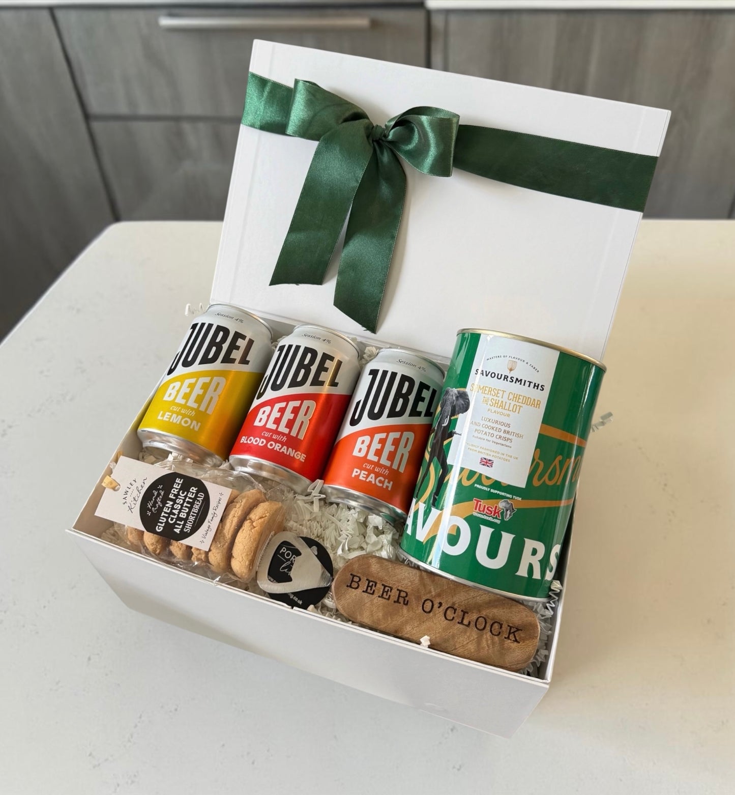 Gift box with JUBEL beer cans and snacks on a kitchen counter