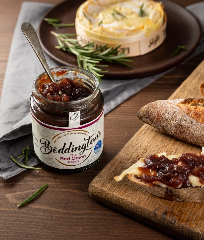Bodgenton's Red Onion Relish jar with bread and cheese on a wooden board