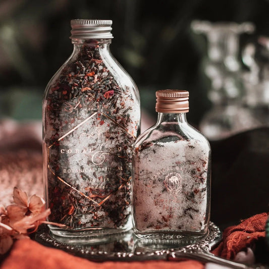 Botanical bath salts in glass jars with rose petals.