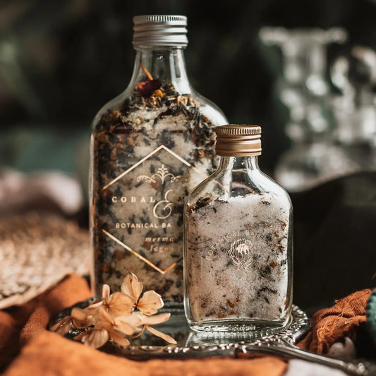 Botanical bath salts in glass jars with citrus-infused blend for a relaxing mermaid lagoon experience.