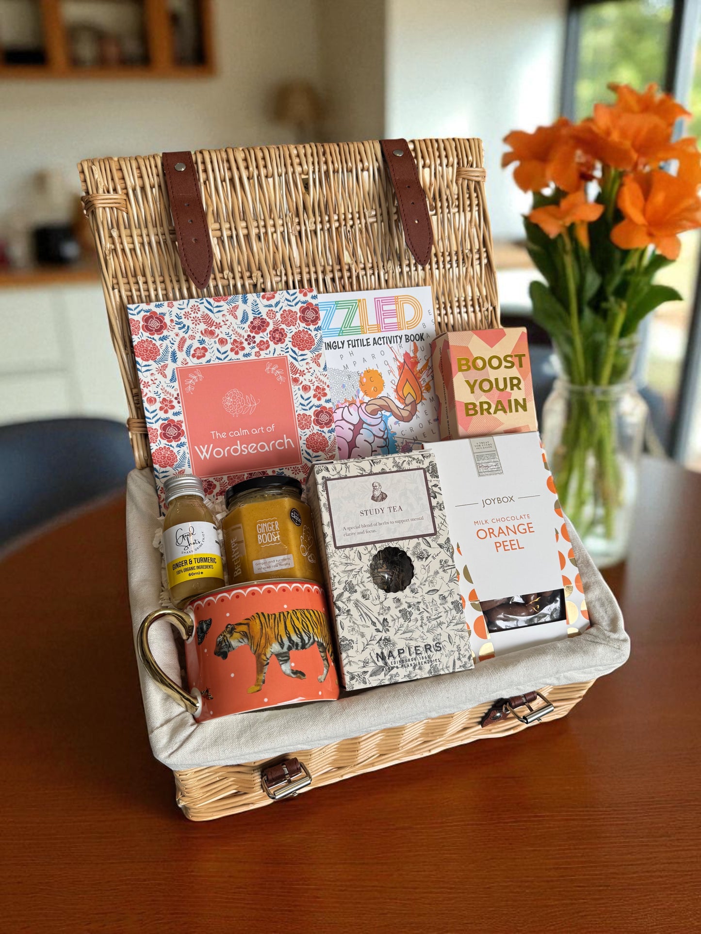 Brain Boost Hamper featuring puzzle books, brain cards, ginger honey turmeric shots, study blend tea, orange peel chocolates & a gold tiger-print mug.