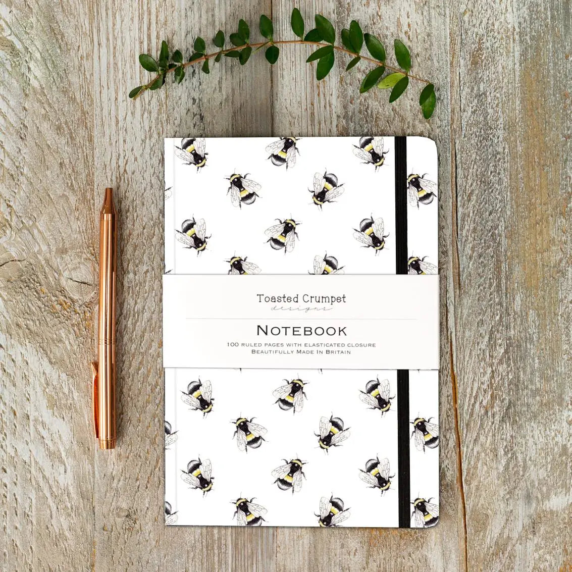 Toasted Crumpet A5 lined notebook with illustrated bumblebee design and black elastic closure.