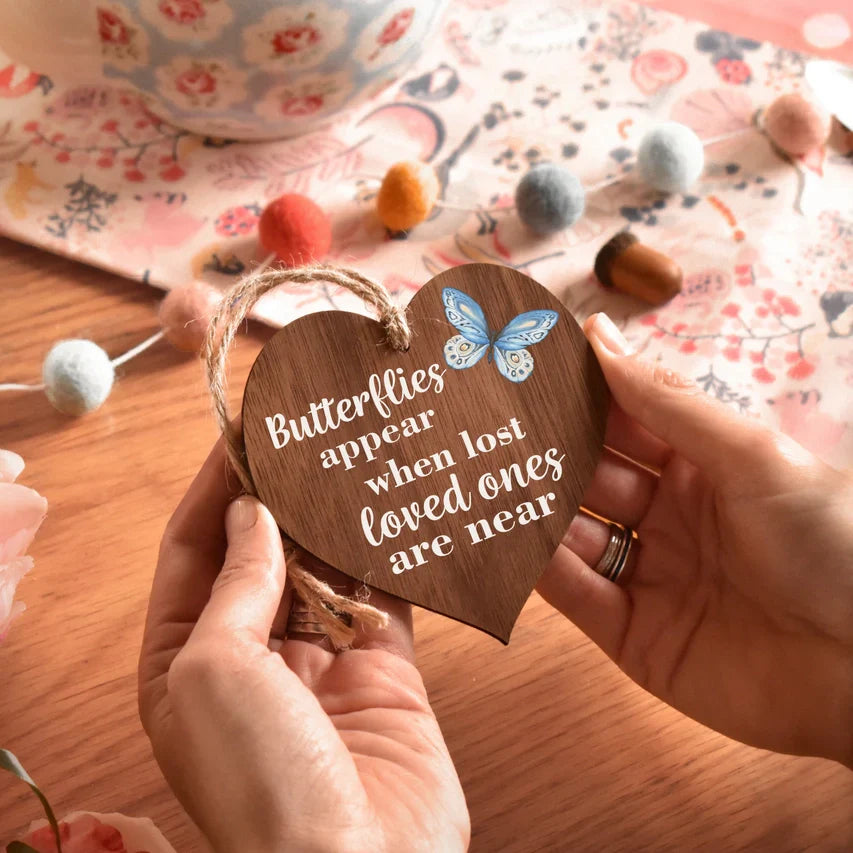Heart-shaped wooden plaque with "Butterflies Appear" text and blue butterfly design.