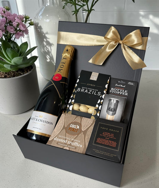 Celebration gift set with Moët & Chandon champagne, black chrome champagne stopper, True Grace candle and luxury chocolates.