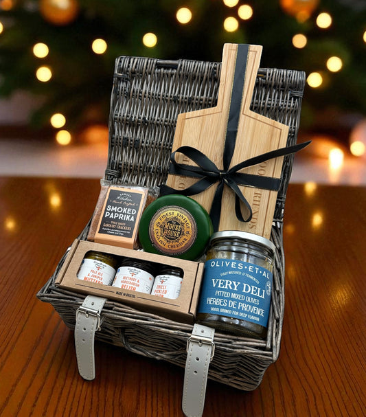 Mini Preserves and Cheeseboard Gift featuring vintage cheddar truckle, three mini preserves, pitted olives, smoked paprika crackers & wooden serving board.