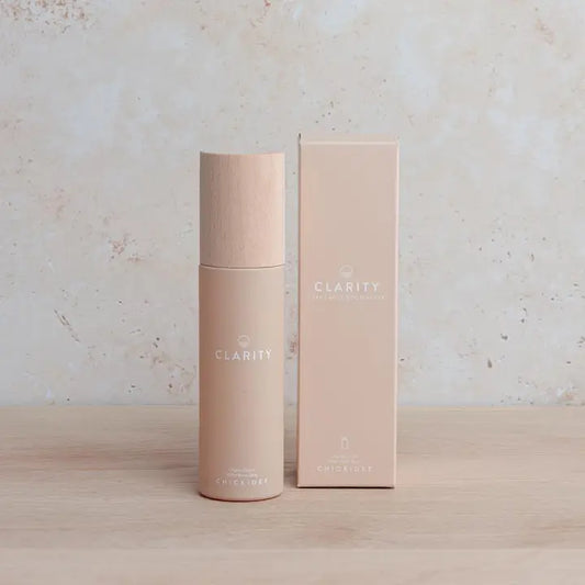 Clarity Room Spray bottle and packaging on a wooden surface.