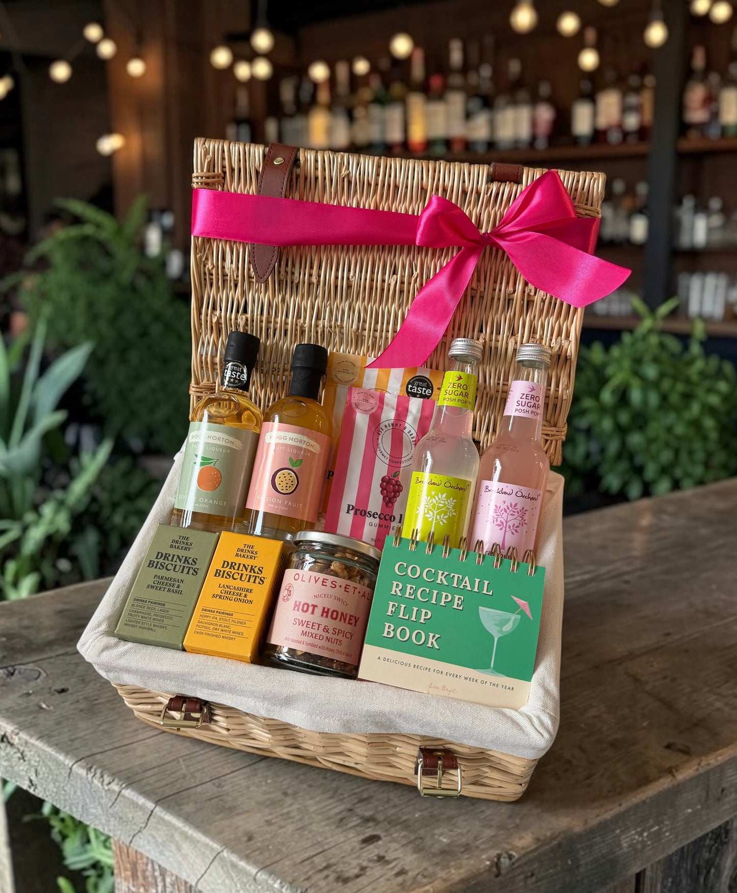Hamper with fruity liqueur, lemonades and a selection of sweet and savoury snacks. 