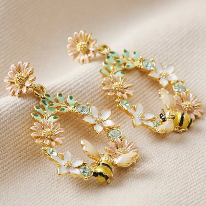 Crystal flower and bee gold plated drop earrings with enamel and blue crystals.