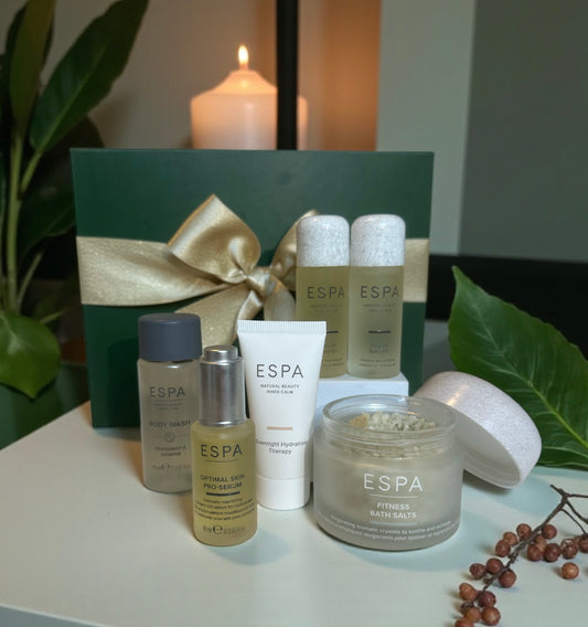 Espa skincare products on a table with a candle and decorative elements. Comes in a gift box. 