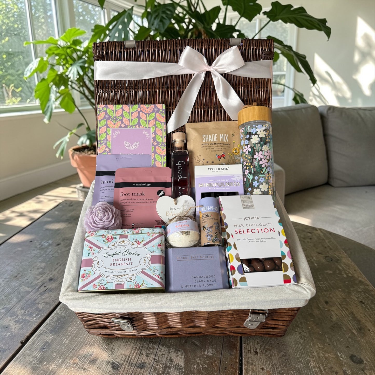 Retirement gift hamper with tea, chocolates, candle, bath treats, seedballs and bramble whisky liqueur.