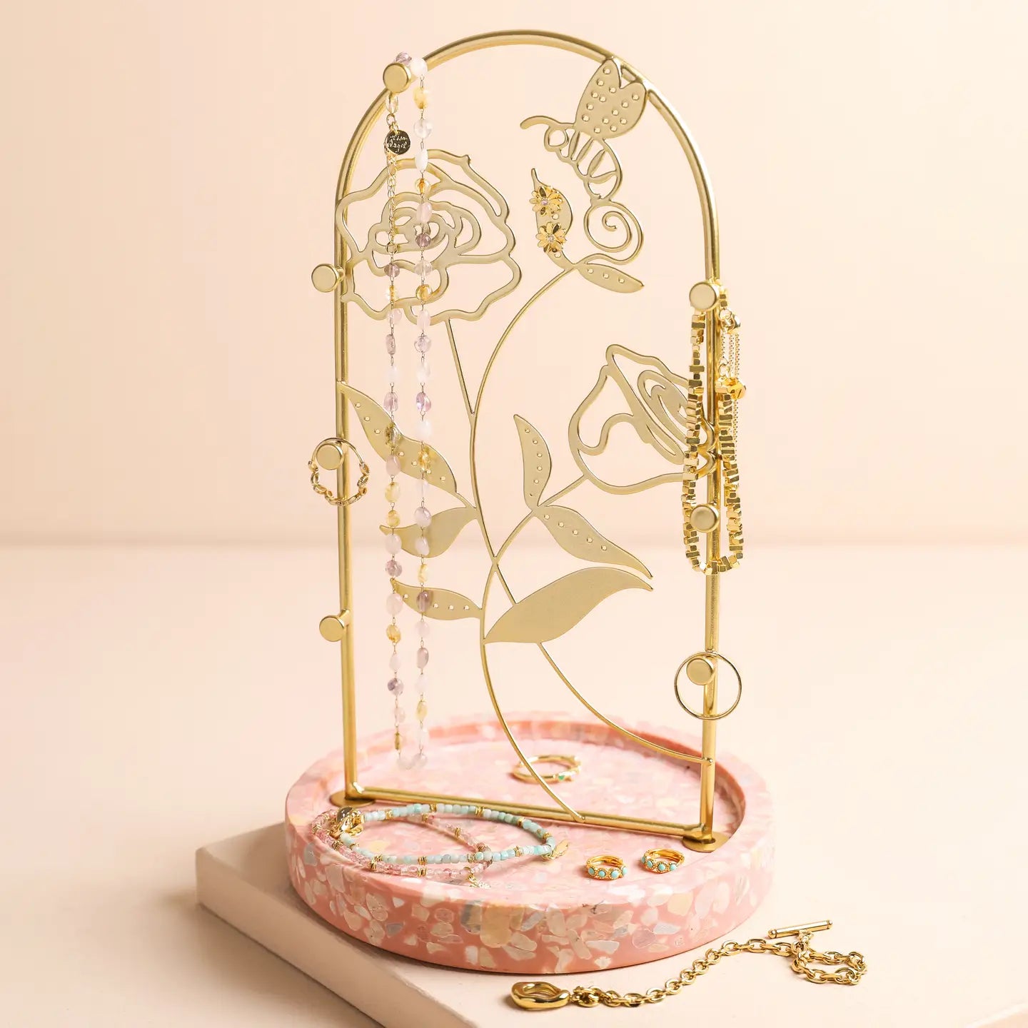 Floral jewellery stand with terrazzo base featuring an arch frame and delicate floral design for hanging chains and bracelets.